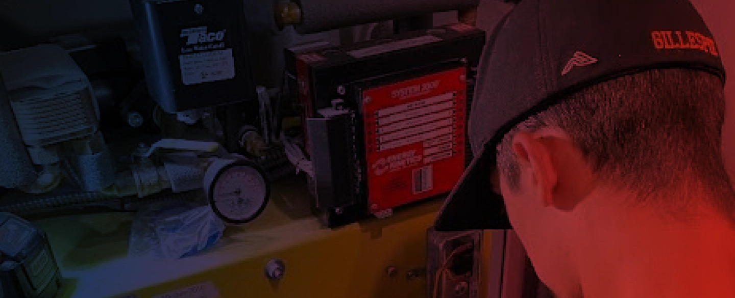 worker with a black gap fixing a yellow water heater machine
